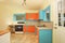Old fashioned kitchen interior with orange and blue cabinets.