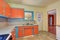 Old fashioned kitchen interior with orange and blue cabinets.