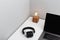 Old-fashioned lamp, wireless headphones and a modern laptop on a white table