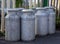 Old fashioned milk churns by fence. Vintage agriculture.