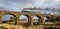 Old Fashioned Steam Train Crossing a Historic Bluestone Masonry Bridge, Malmsbury, Victoria, Australia, June 2019