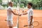 old-fashioned tennis players with wooden rackets shaking hands after game