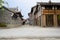 Old-fashioned tile-roofed buildings by flagstone street in cloud