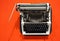 Old-fashioned typewriter on a bright orange background