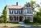 Old fashioned Victorian house with peeling paint is all decked out for the 4th of July or Memorial Day in the USA