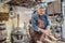 Old-fashioned way of processing wood as aged carpenter holds tools to smooth the wooden surface