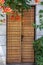 Old fashioned wooden door made from horizontal narrow planks and beautiful orange flowers above.