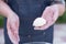 Old female wearing blue apron holding dough, rolling buns, showing, dusting with flour.