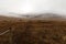 An old fence crosses a dreary, foggy, empty, and barren winter landscape at the National Bison Range wildlife refuge, Montana, USA