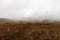 An old fence crosses a dreary, foggy, empty, and barren winter landscape at the National Bison Range wildlife refuge, Montana, USA