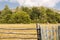 Old fence made of wood with gate in countryside. Beautiful summer landscape with forest and mountain. Rustic lifestyle concept