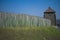 old fence of a stockade and watchtower against a blue sky background