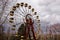 An old Ferris wheel with rusted structure and yellow seats