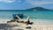 An old fishing boat by the beach on a clear blue turquoise