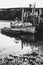 An old fishing boat is moored on the water. Black and white photo. Dramatic landscape.