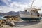 Old fishing boat on the shore. A ship pulled ashore. Harbor in the village of Hersonissos on the island of Crete, Greece.