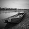 An old fishing boat stranded on the bank of the Sava River in Bosanski Brod, Bosnia and Herzegovina. Black and white picture of a