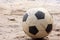 An old football or soccer ball on sand