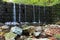 Old forgotten dam in the middle of the forest. Focus on waterfall. Motion photography. Forest stream in autumn.