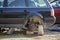 Old forsaken rusty broken trash car after crash accident without wheels on wood stamps covered with snow on winter day outdoors