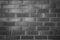 Old, frayed black and white brick wall texture, background