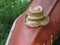 Old Frayed Straw Hat with Tattered Brim Resting on a Red Canoe After the Paddle