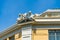 Old French house with traditional windows. Villefranche-sur-mer, France. Two sculptures of angels on the roof. Clear sky