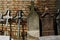 Old funeral stones and metal crosses supported by the wall of a church in the cemetery.