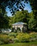 An old garden house embedded in the lush green plants and trees in the botanical garden of Lund, Sweden