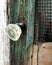 Old glass door knob covered with snow on a dilapidated old wooden screen door