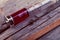 Old glass syringe on the grunge wooden surface