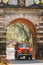 Old Goa, India. Red Truck Moving Through The Old Viceroy s Arch. Famous Vasco Da Gama Gate Landmark And Historical