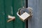 Old gold padlock covered with rust on a green door