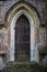 Old gothic arched door with wooden door in a stone wall