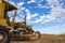 Old Grader tractor machine on construction site and the blue sky background