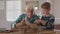 Old grandfather and child assembling wooden plane together