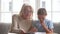 Old grandmother helping granddaughter school child girl with homework