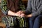 An old grandmother and a young girl granddaughter are sitting in a room. Hands of the girl hold hands of an old woman