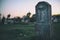 Old grave on traditional European cemetery. Scary graveyard with foggy background. Close up of aged spooky tomb stone on grave