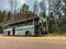 An old gray bus is abandoned on a road in the woods. Forest landscape with forgotten vintage gray bus. shattered commercial