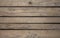 A old gray darkened wooden boards with black slots between them, horizontal lines. natural surface texture