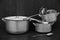 Old gray dishes with katatrylyami and spoons on the table near the wall