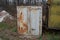 Old gray iron container in rust with a closed door