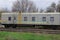 Old gray passenger car with windows on the railway