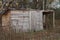 Old gray plank shed stands on nature