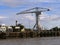 Old gray Titan construction crane and the Buren rings on the banks of the Loire in Nantes