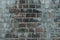 Old gray vintage weathered brick wall texture of ancient castle. Grunge rough block stonewall, masonry structure surface pattern