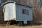 Old gray wooden trailer on wheels stands in dry grass on nature