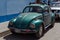 Old green beetle car in street of latin american country