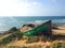 Old green boat resting on the beach. An abandoned boat in the dusk. Abandoned wrecked boat stuck in sand